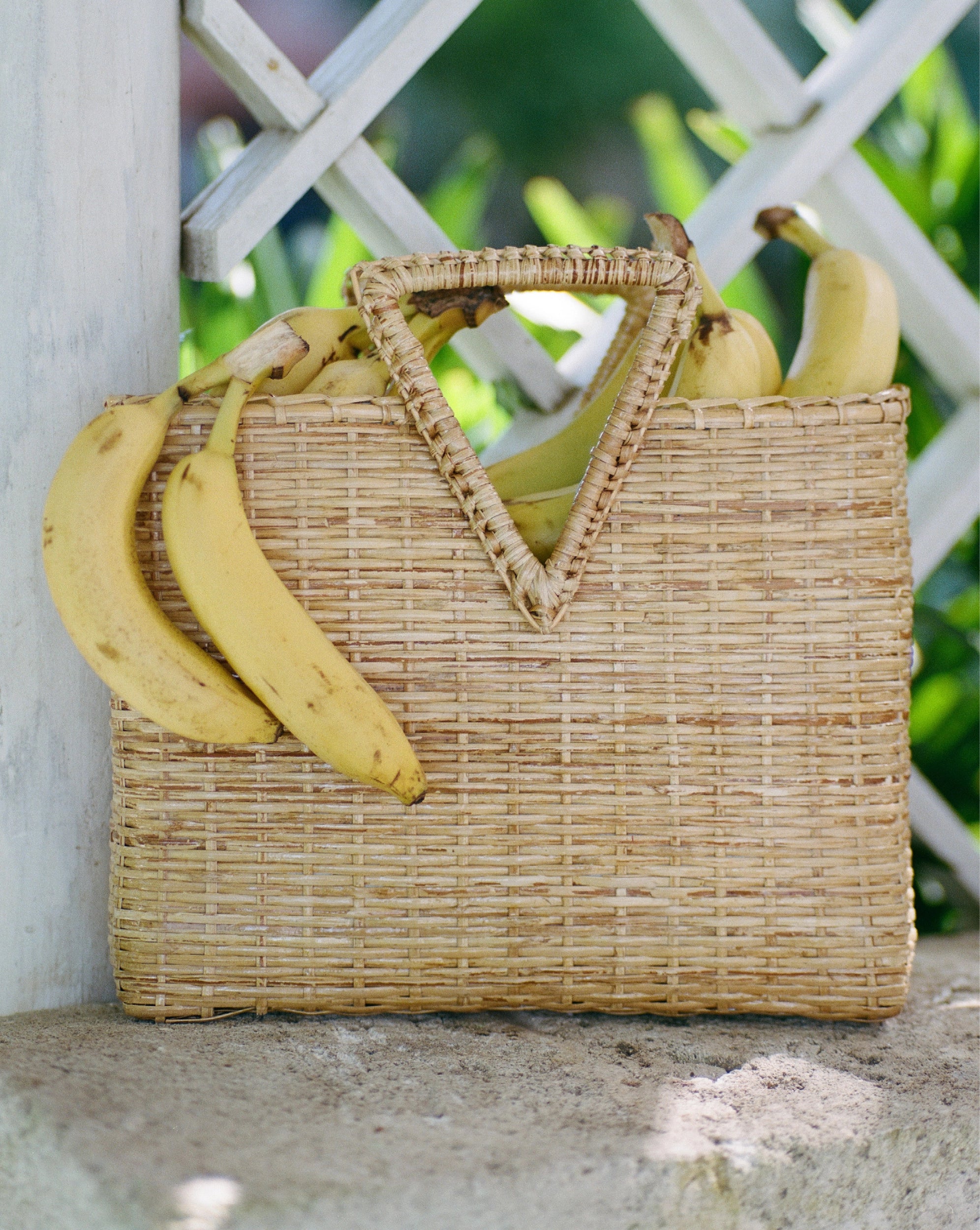 Veronica Beard Woven straw tote bag with triangular handles and a patterned fabric lining.