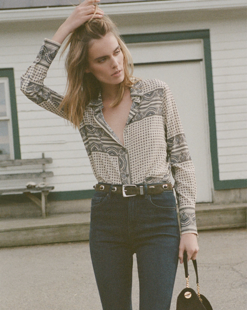 Veronica Beard White patterned silk shirt, dark wash wide-leg jeans.