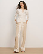 Veronica Beard Cream button-front cardigan with black text on the chest and two-tone beige wide-leg trousers.