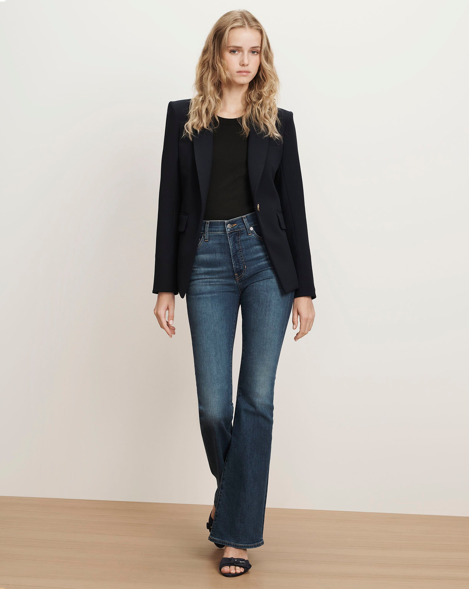 Veronica Beard Navy blazer, black top, and flared jeans.