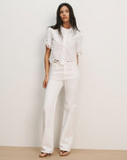 Veronica Beard White eyelet short-sleeve button-up shirt and white wide-leg jeans.