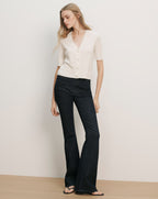 Veronica Beard Cream short-sleeve knit cardigan with dark wash flared jeans.