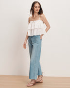 Veronica Beard White tiered ruffle camisole with light wash wide-leg jeans and black lace-up sandals.