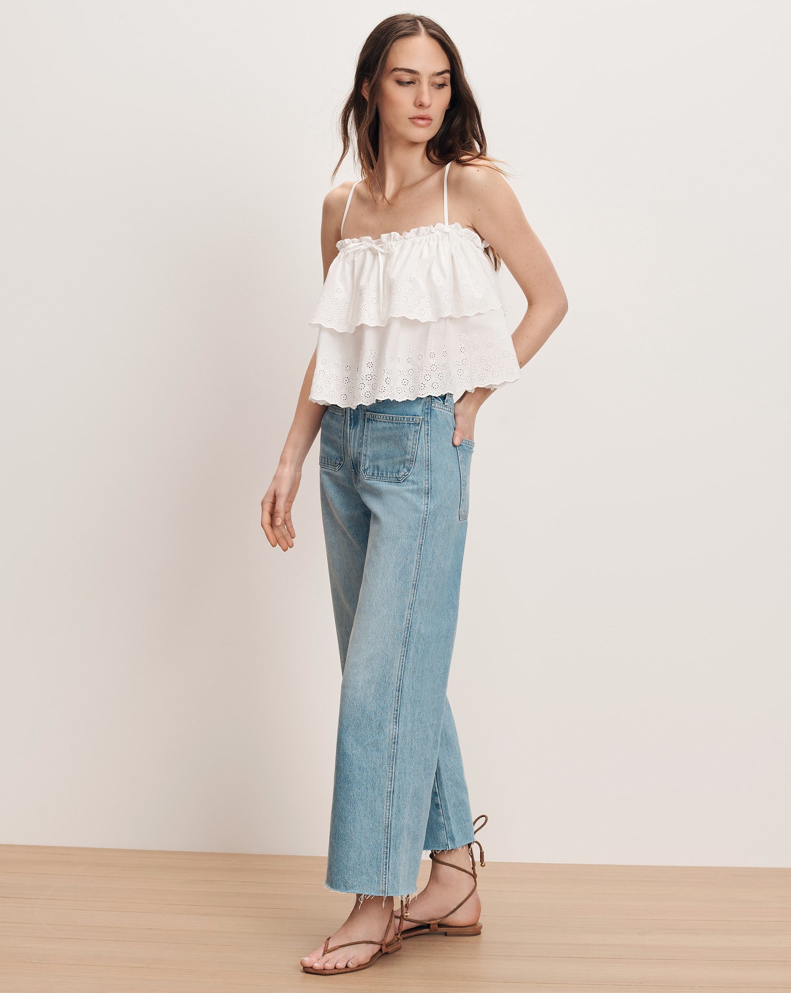 Veronica Beard White tiered ruffle camisole with light wash wide-leg jeans and black lace-up sandals.