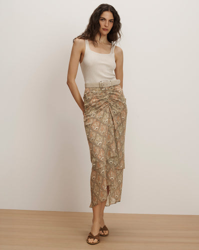Veronica Beard Ribbed cream tank top and a sheer, ruched midi skirt with a beige paisley print and a matching belt.