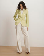Veronica Beard Light green double-breasted blazer with peak lapels, paired with a white collared shirt and cream wide-leg trousers.