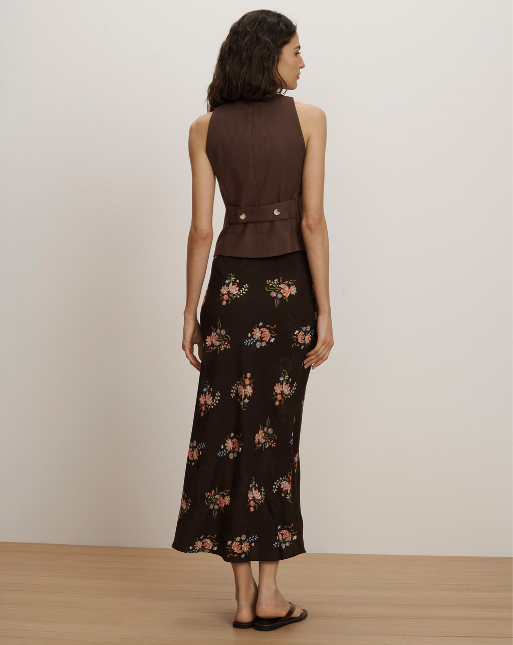 Veronica Beard Brown sleeveless vest with silver buttons and a black floral midi skirt.