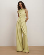 Veronica Beard Light green sleeveless vest with gold buttons and matching wide-leg pleated trousers.