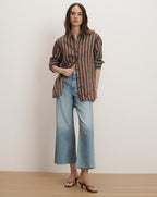Veronica Beard striped button-up shirt and wide-leg denim jeans, paired with brown sandals.