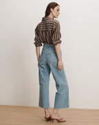 Veronica Beard Brown and white striped button-down shirt with light wash wide-leg jeans.