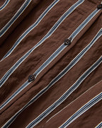 Veronica Beard Brown and white striped button-down shirt with rolled sleeves, paired with light wash denim jeans.