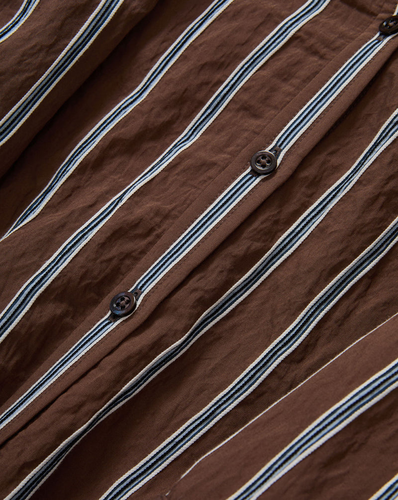 Veronica Beard Brown and white striped button-down shirt with rolled sleeves, paired with light wash denim jeans.