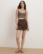 Veronica Beard Brown and white striped bustier crop top with brown pleated shorts.