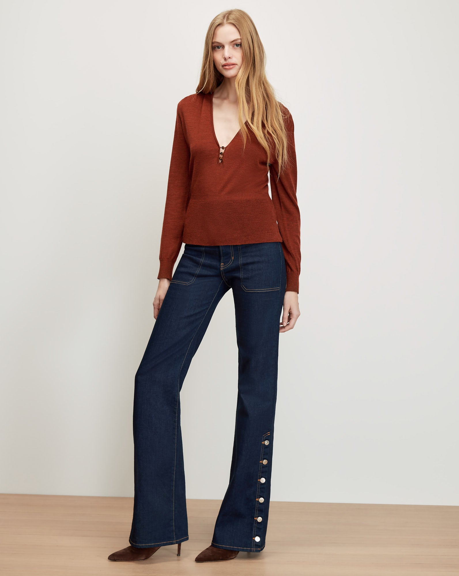 Veronica Beard Brown knit sweater, dark wash flared jeans with buttons.