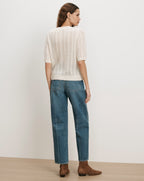 Veronica Beard White knit short-sleeve sweater and blue jeans.