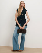 Veronica Beard Navy sleeveless blazer, wide-leg jeans, brown suede handbag.