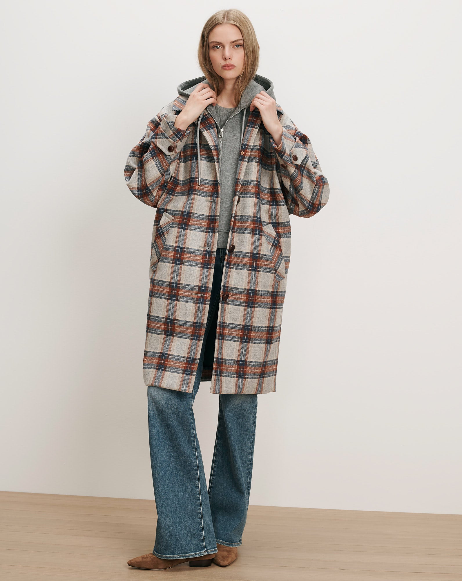 Veronica Beard Plaid wool coat, gray hoodie, blue jeans.