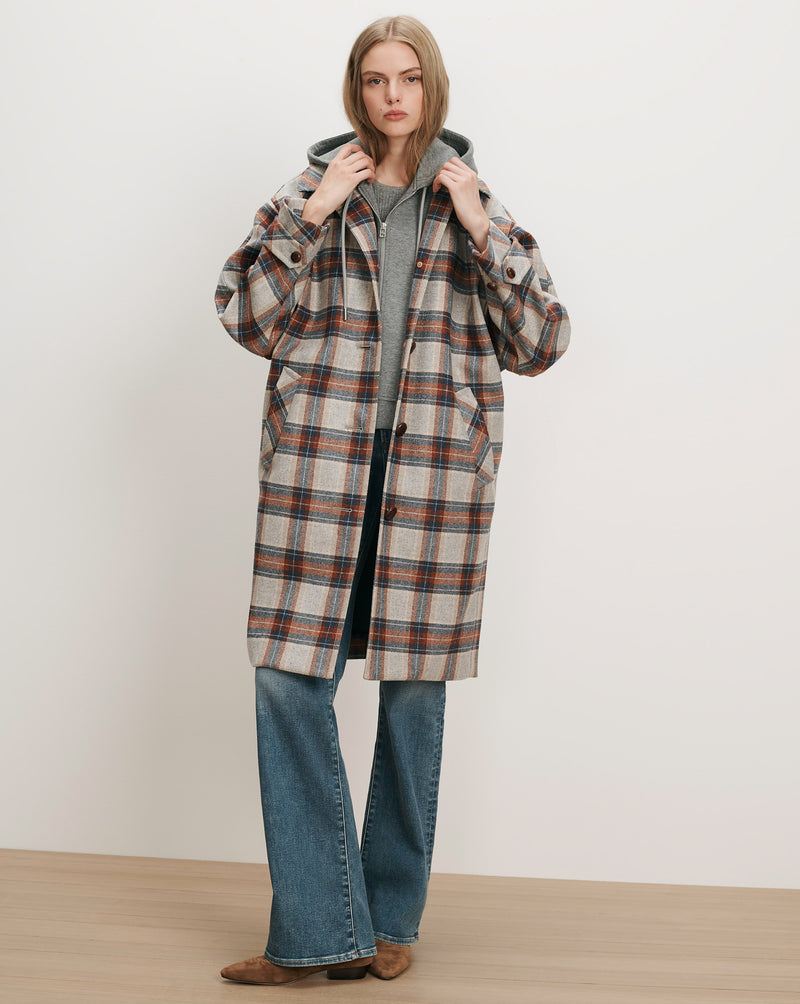 Veronica Beard Plaid wool coat, gray hoodie, blue jeans.