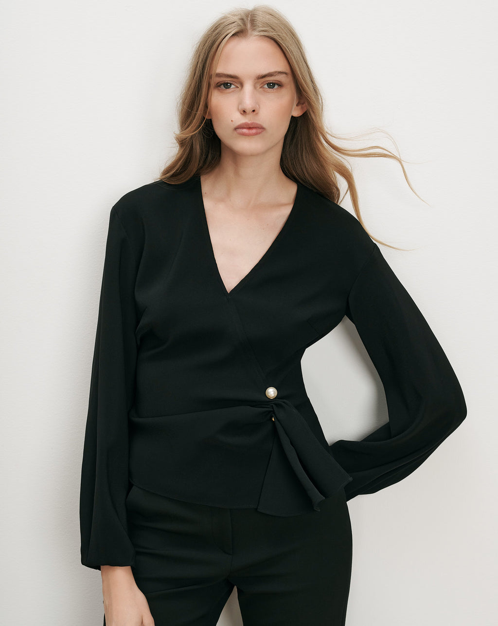 Veronica Beard Black wrap blouse with pearl button.