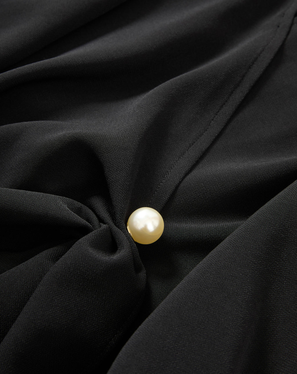 Veronica Beard Black blouse with a pearl button.