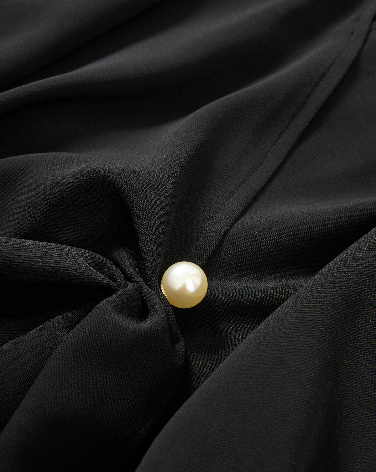 Veronica Beard Black blouse with a pearl button.