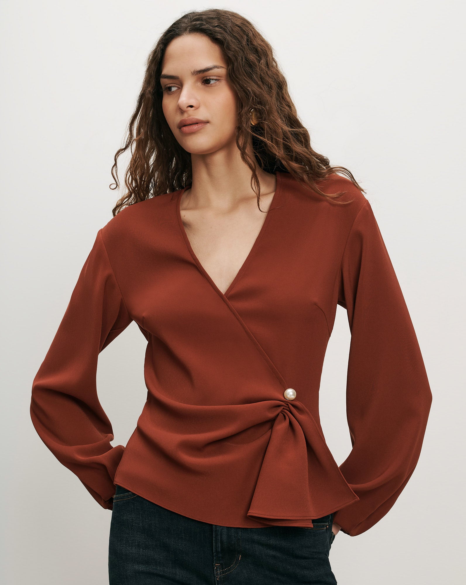 Veronica Beard Rust wrap blouse with pearl button detail.