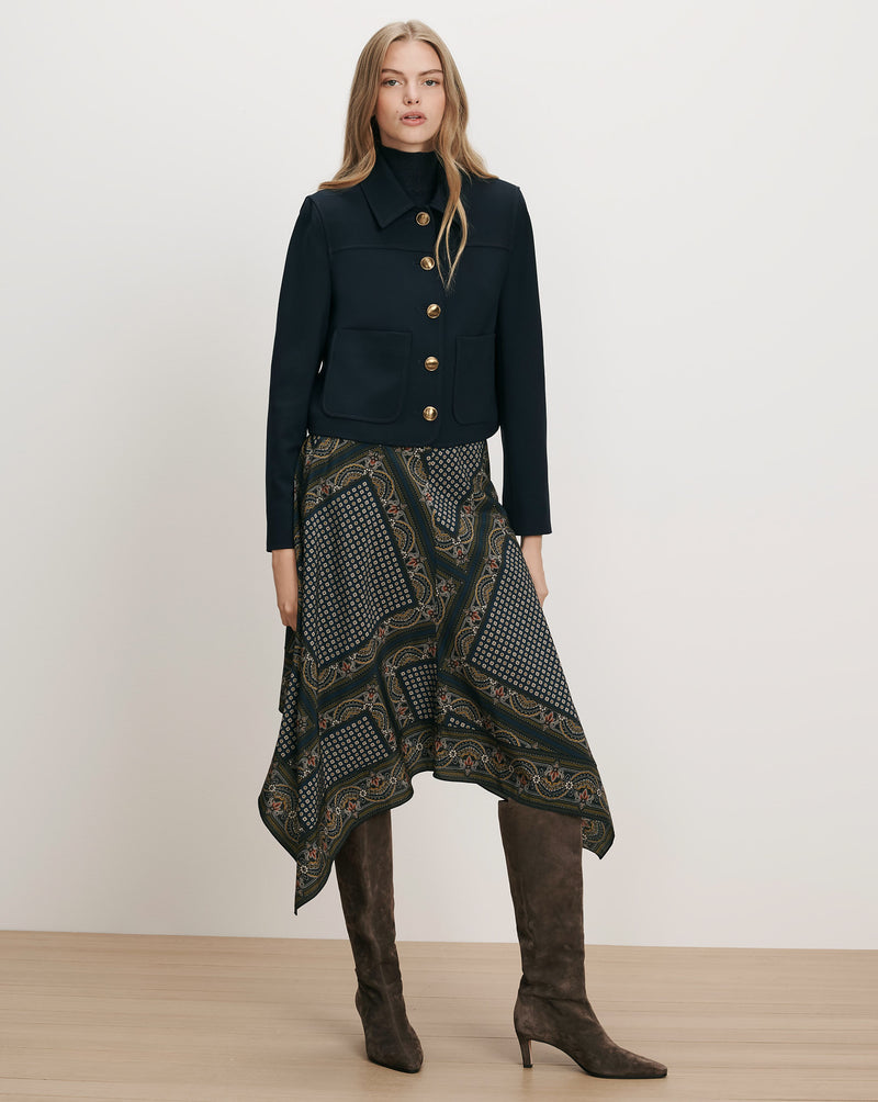 Veronica Beard Navy jacket, patterned skirt, brown boots.