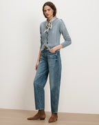Veronica Beard Blue cable knit cardigan, jeans, brown boots, and patterned scarf.