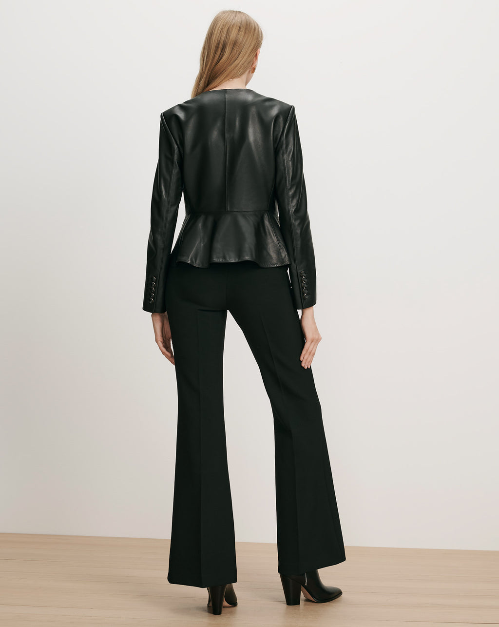 Veronica Beard Black leather peplum jacket and black flared trousers.