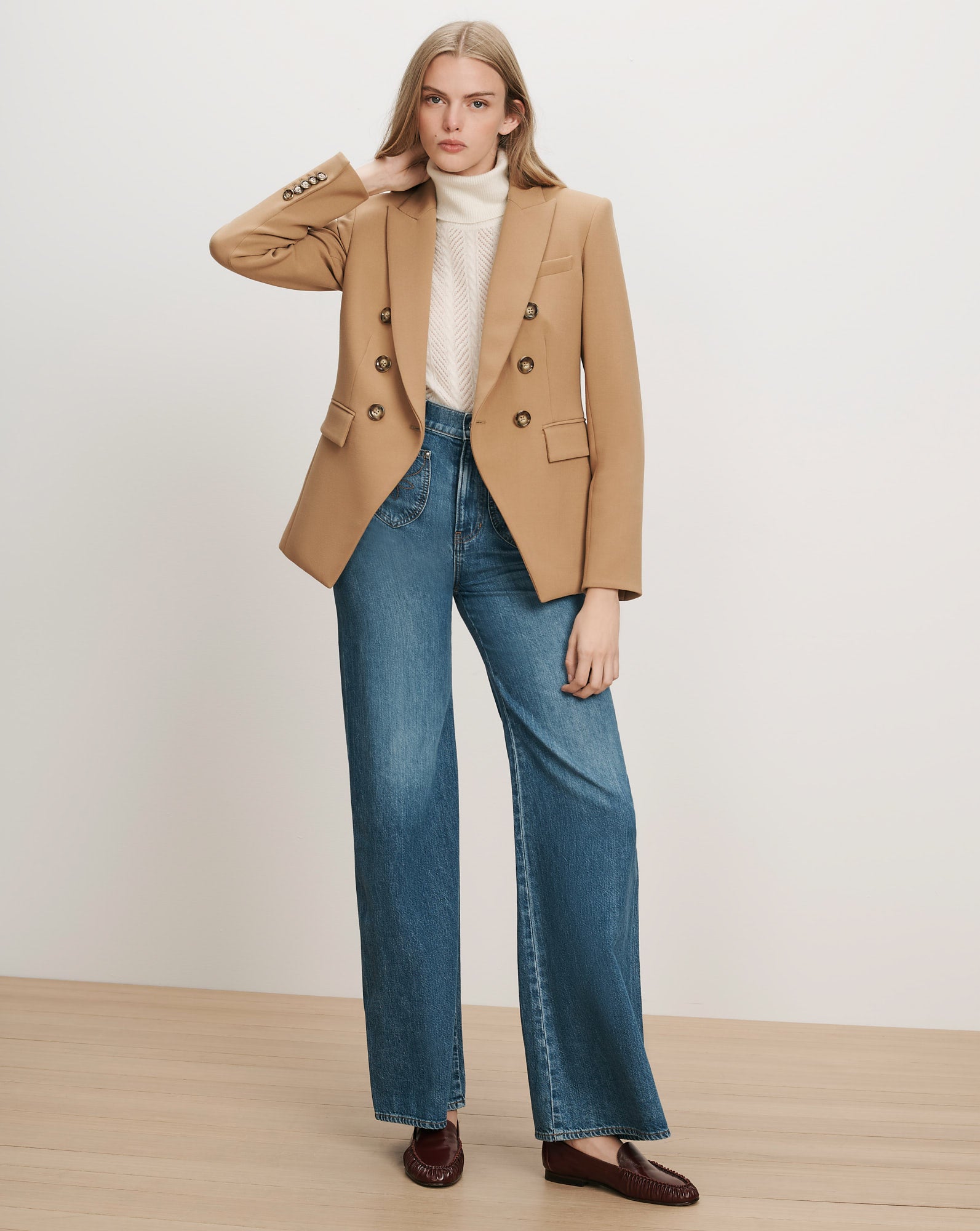 Veronica Beard Camel double-breasted blazer, cream knit turtleneck, wide-leg jeans.