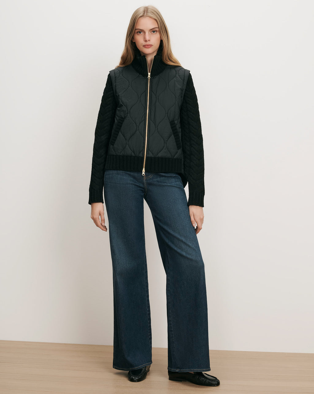Veronica Beard Black quilted vest with knit sleeves and gold zipper.