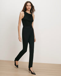 Veronica Beard Black sleeveless top with pearl button and black pants.