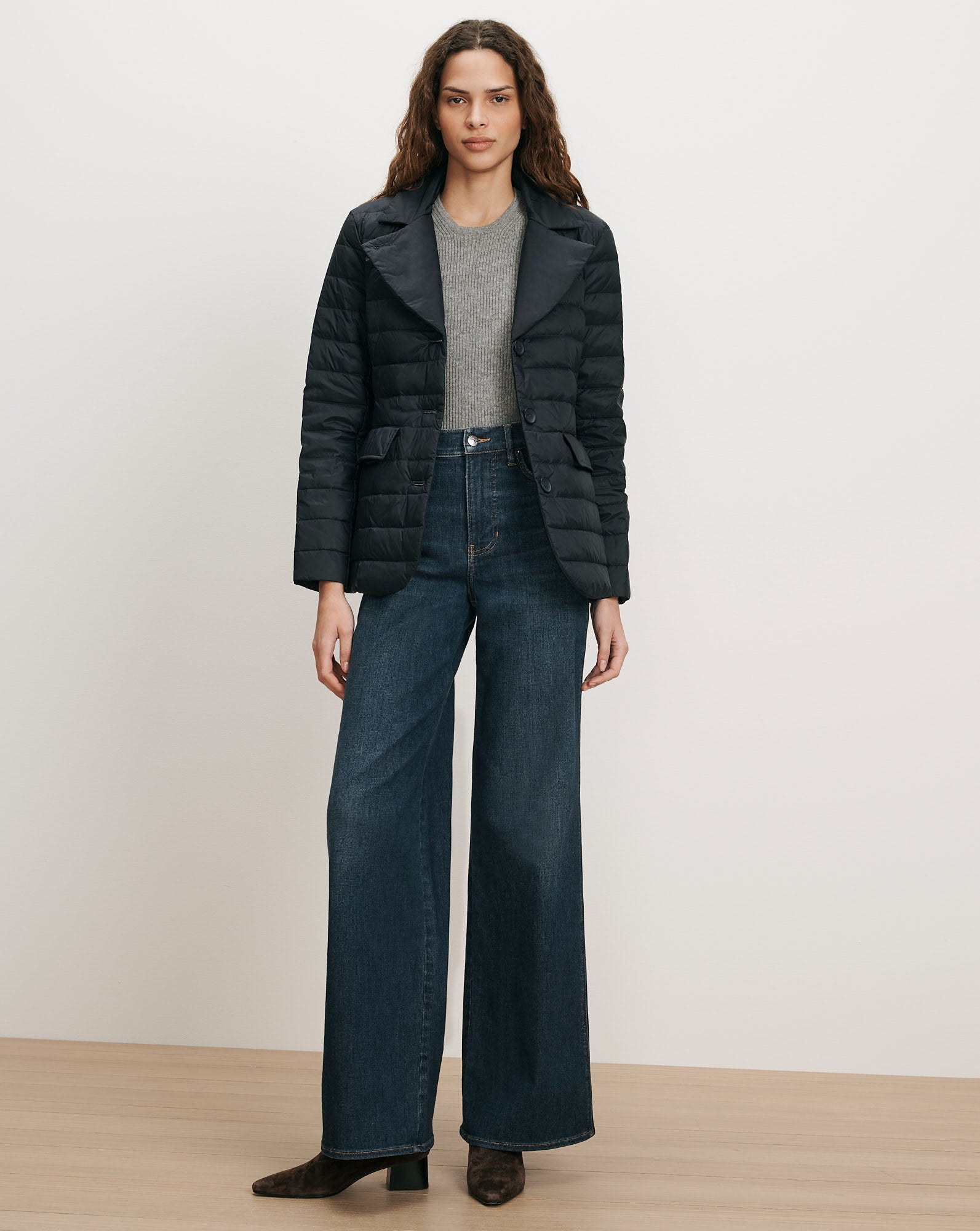 Veronica Beard Black quilted jacket, gray sweater, dark wash wide-leg jeans.