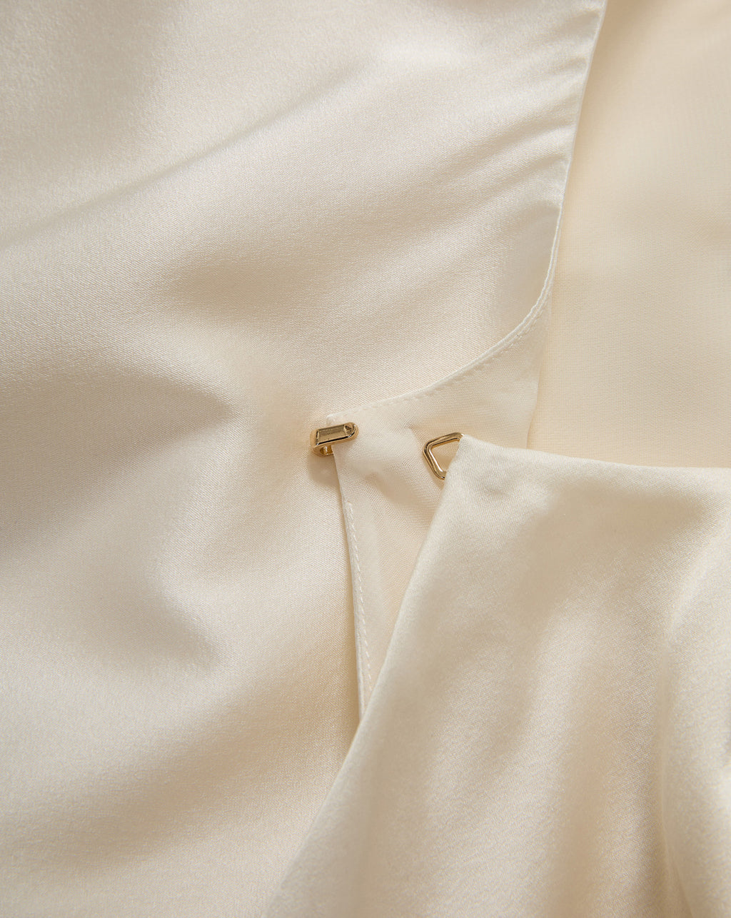 Veronica Beard Cream satin blouse with hook-and-eye closure.