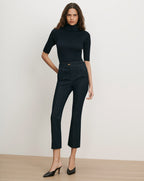 Veronica Beard Black ribbed turtleneck top and dark wash flared jeans.