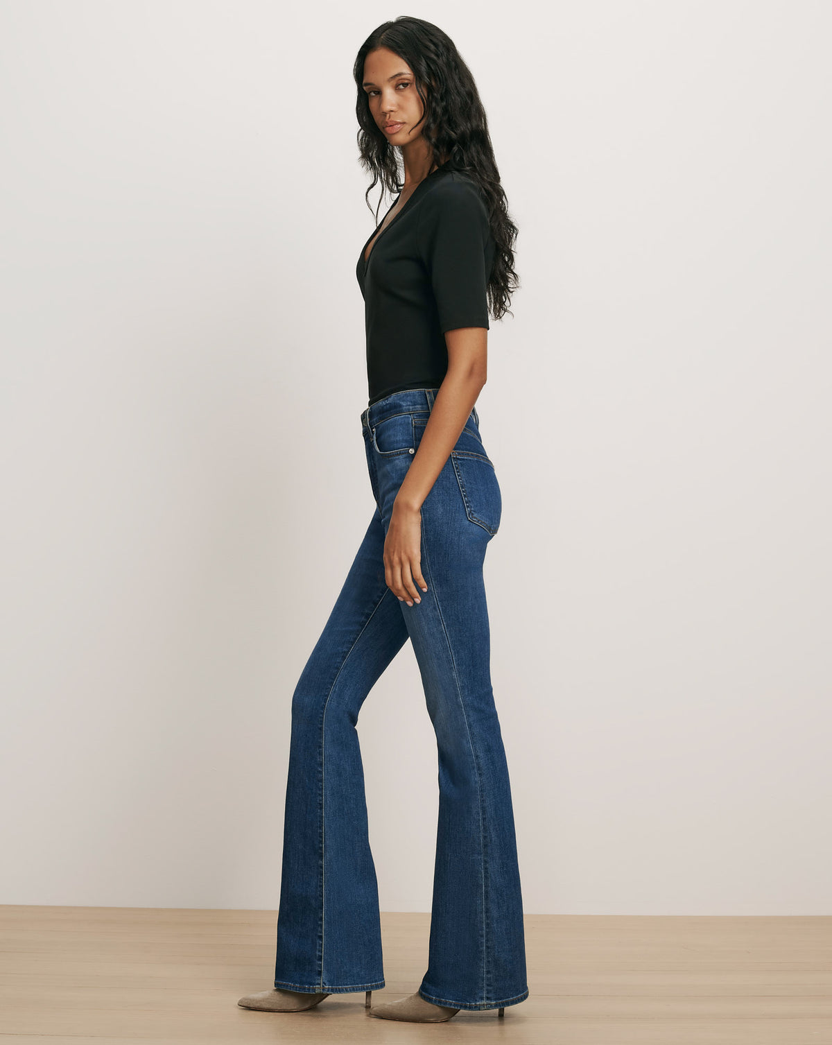 Veronica Beard Black short-sleeve V-neck top and blue flare jeans.