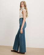 Veronica Beard White sleeveless turtleneck sweater, blue wide-leg jeans