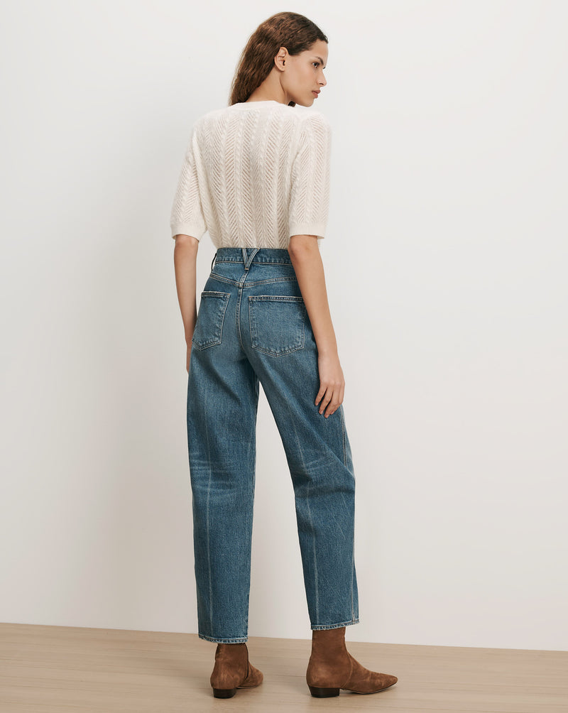 Veronica Beard White knit short-sleeve sweater, blue straight-leg jeans.