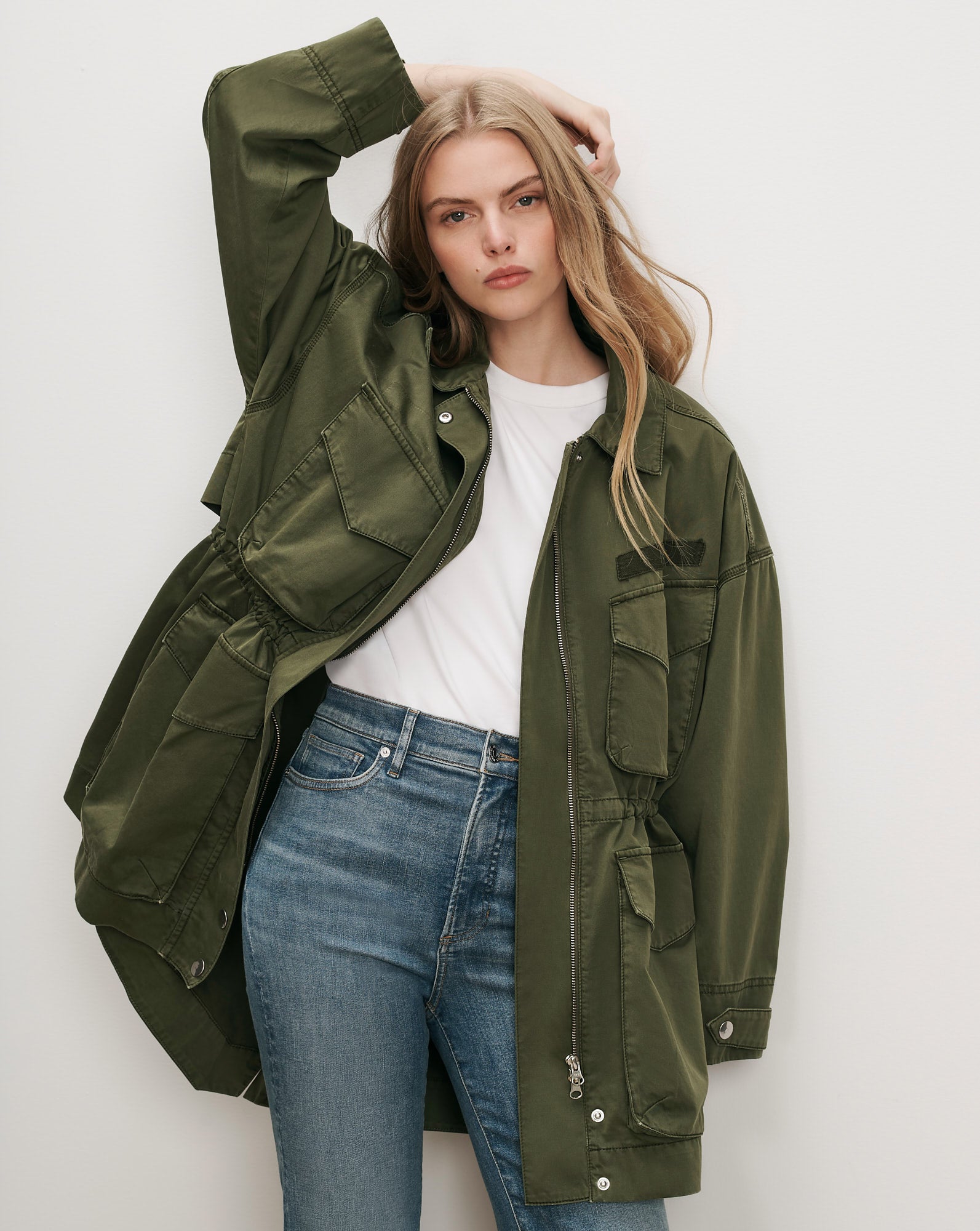 Veronica Beard Olive green utility jacket, white t-shirt, blue jeans.