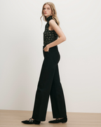 Veronica Beard Black floral sleeveless turtleneck, black wide-leg jeans.