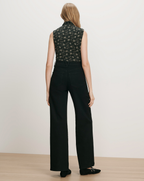 Veronica Beard Black floral sleeveless top and black wide-leg jeans.