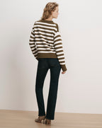 Veronica Beard Olive and white striped knit sweater and dark wash jeans.