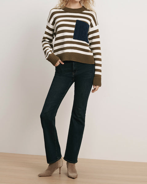 Veronica Beard Striped sweater with a navy pocket, dark wash jeans, and taupe boots.
