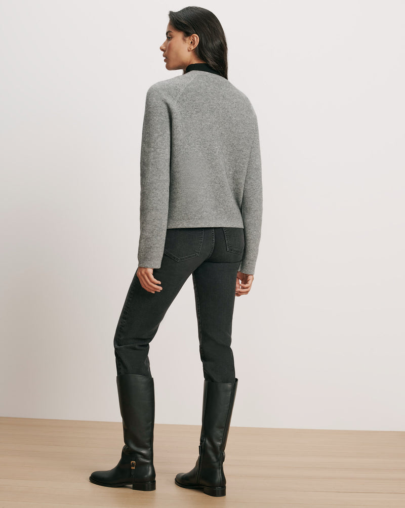 Veronica Beard Gray crewneck sweater, black jeans, black leather boots.