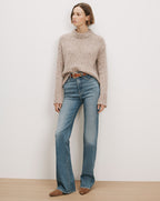Veronica Beard Beige knit mock neck sweater and blue flare jeans.