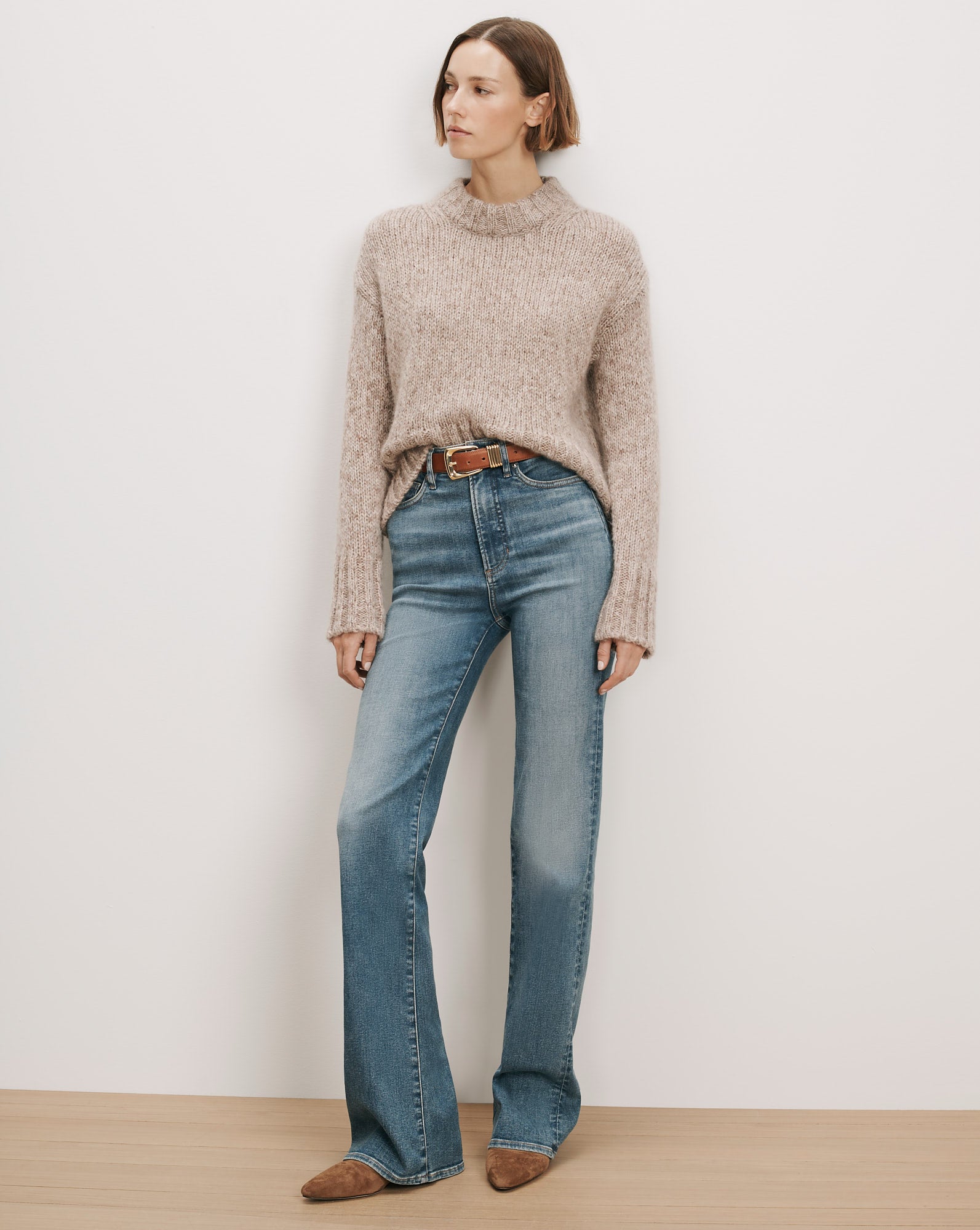Veronica Beard Beige knit mock neck sweater and blue flare jeans.
