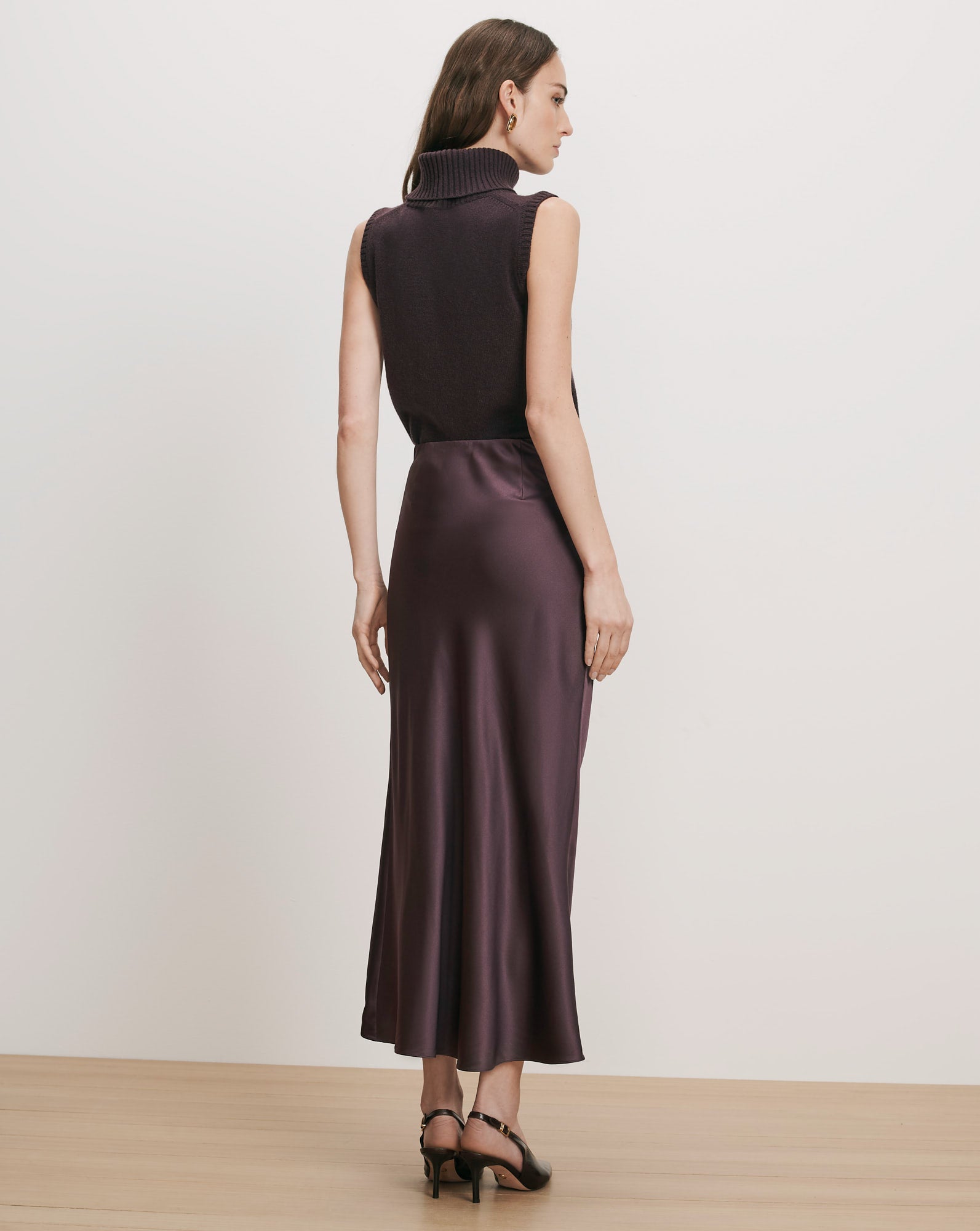 Veronica Beard Brown sleeveless turtleneck and plum satin midi skirt.