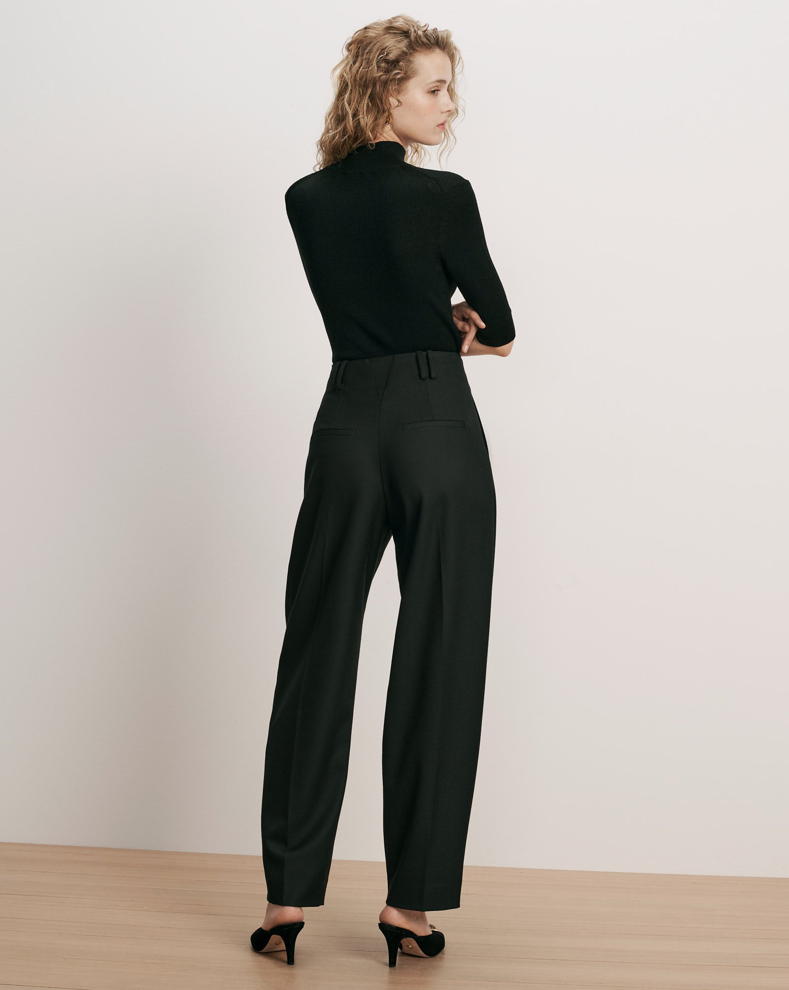 Veronica Beard Black ribbed turtleneck and black wide-leg trousers.