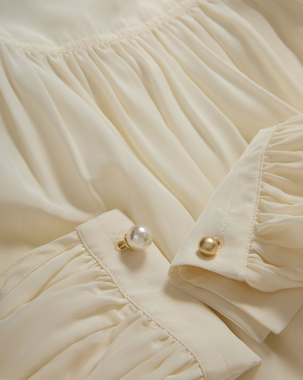 Veronica Beard Cream pleated blouse with pearl and gold buttons.