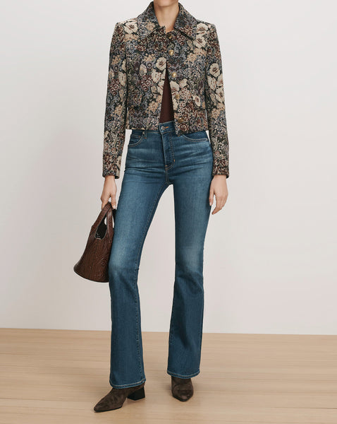 Veronica Beard Floral patterned cropped jacket and blue flared jeans.